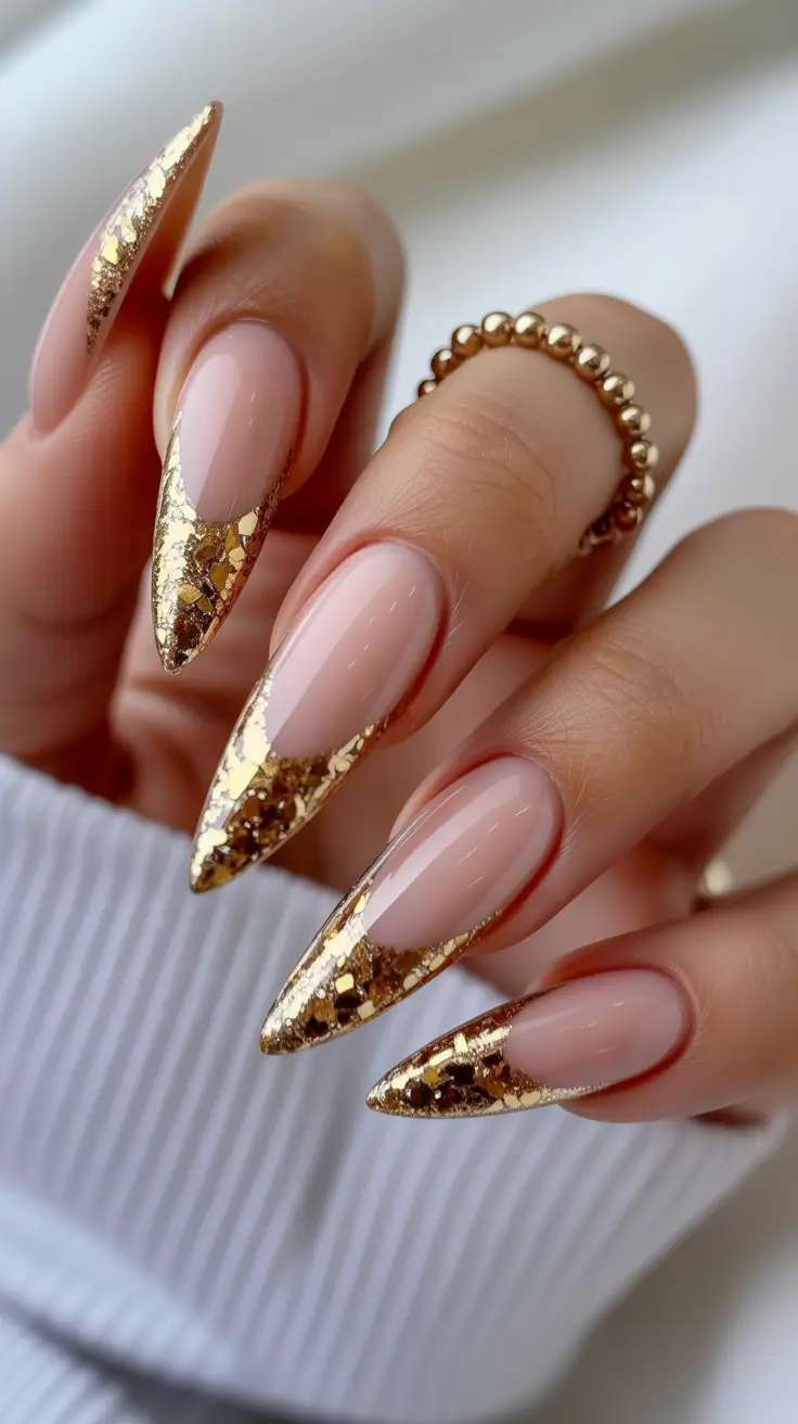 gold nail designs 2026 Sharp Stiletto Nude with Dense Gold Foil Tips