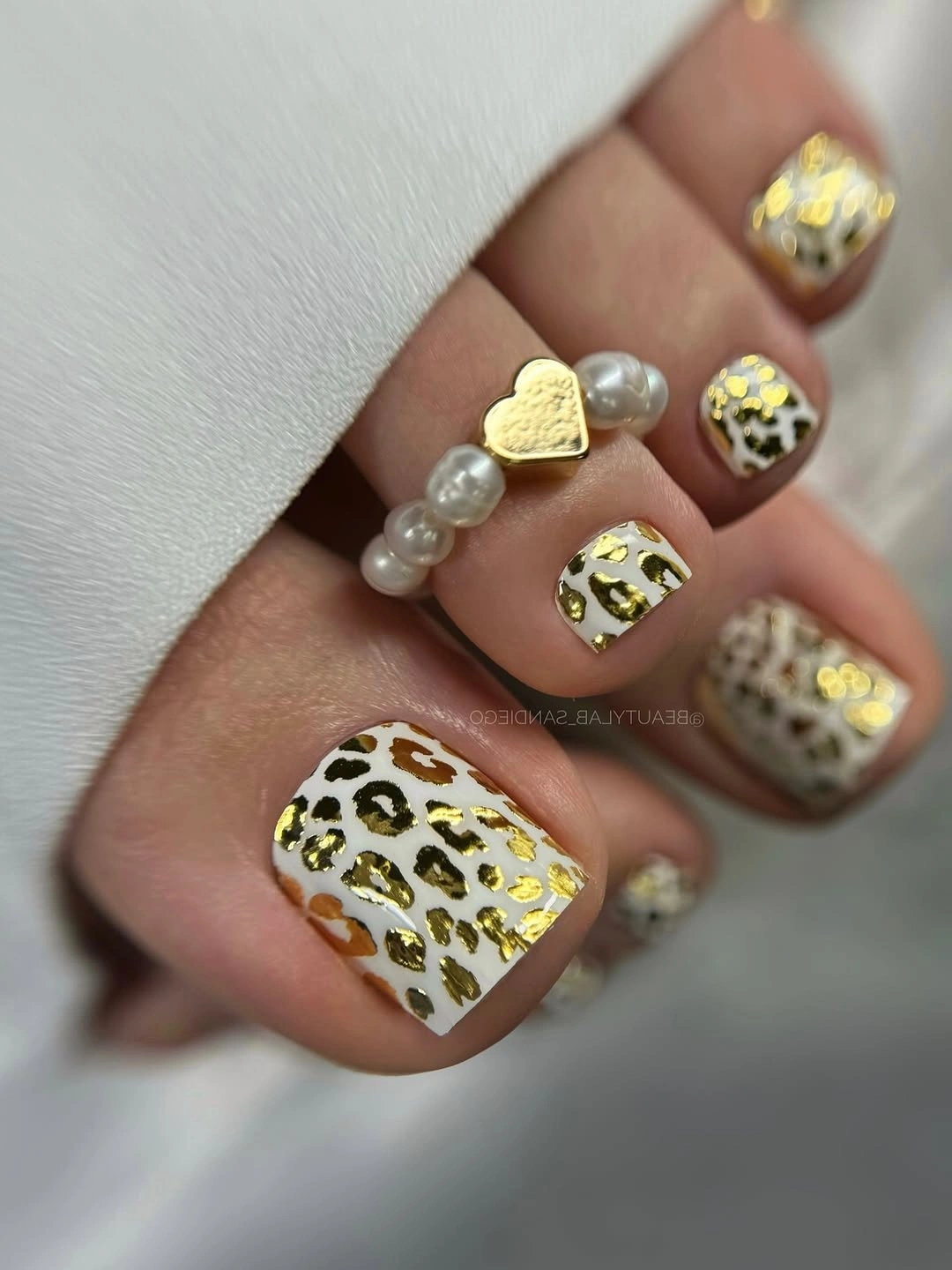 august pedicure nails ideas 2026 White and Gold Leopard for a Luxe Fashion Statement
