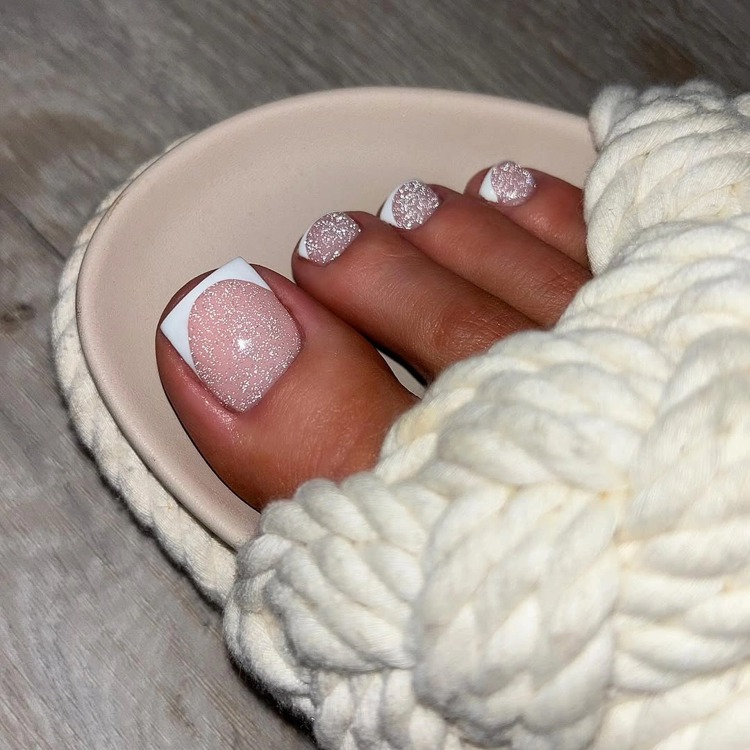 august toe nails 2026 Soft Pink Glitter French Pedicure with Timeless Elegance
