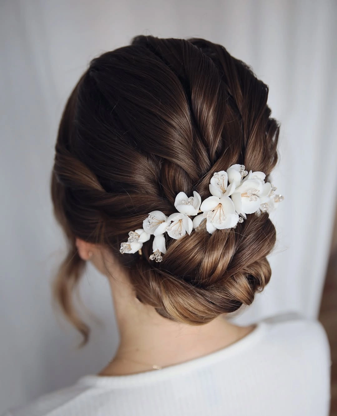bridesmaid hairstyling Elegant Twisted Bun with Floral Accent