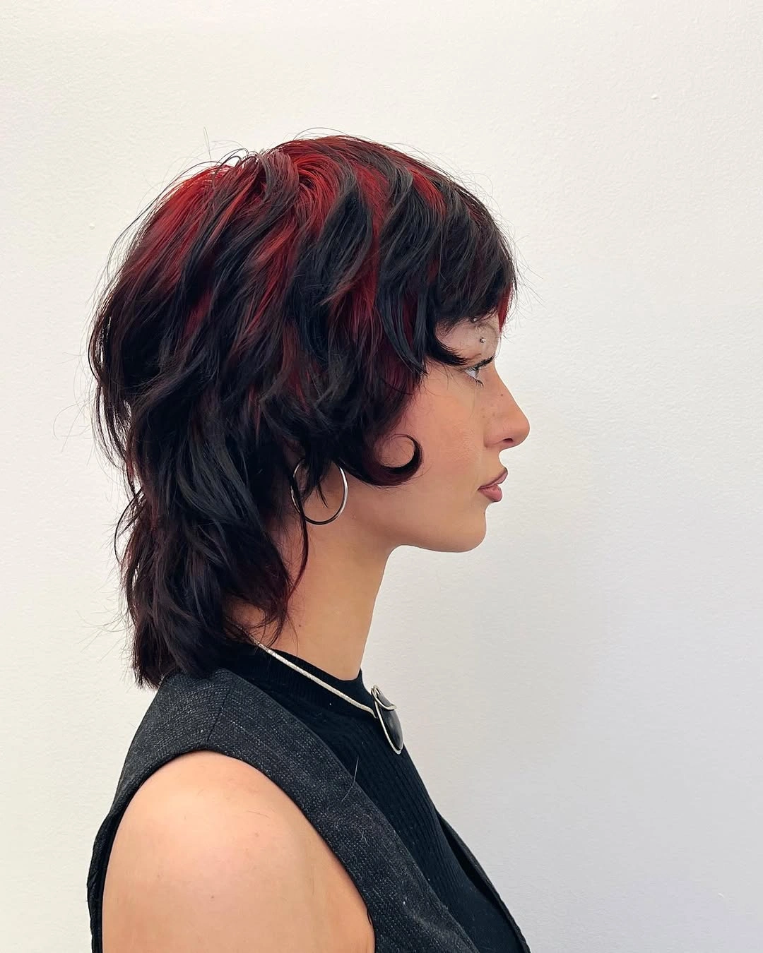 fall hairstyles 2026 Edgy Wolf Bob With Crimson Peekaboo Highlights