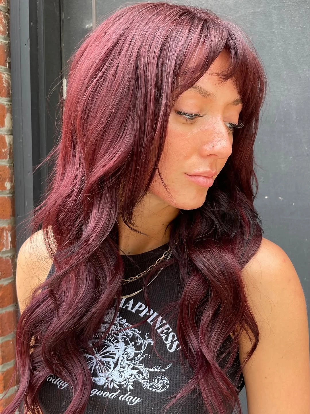 fall hairstyles 2026 Rich Black Cherry Waves With Soft Curtain Fringe