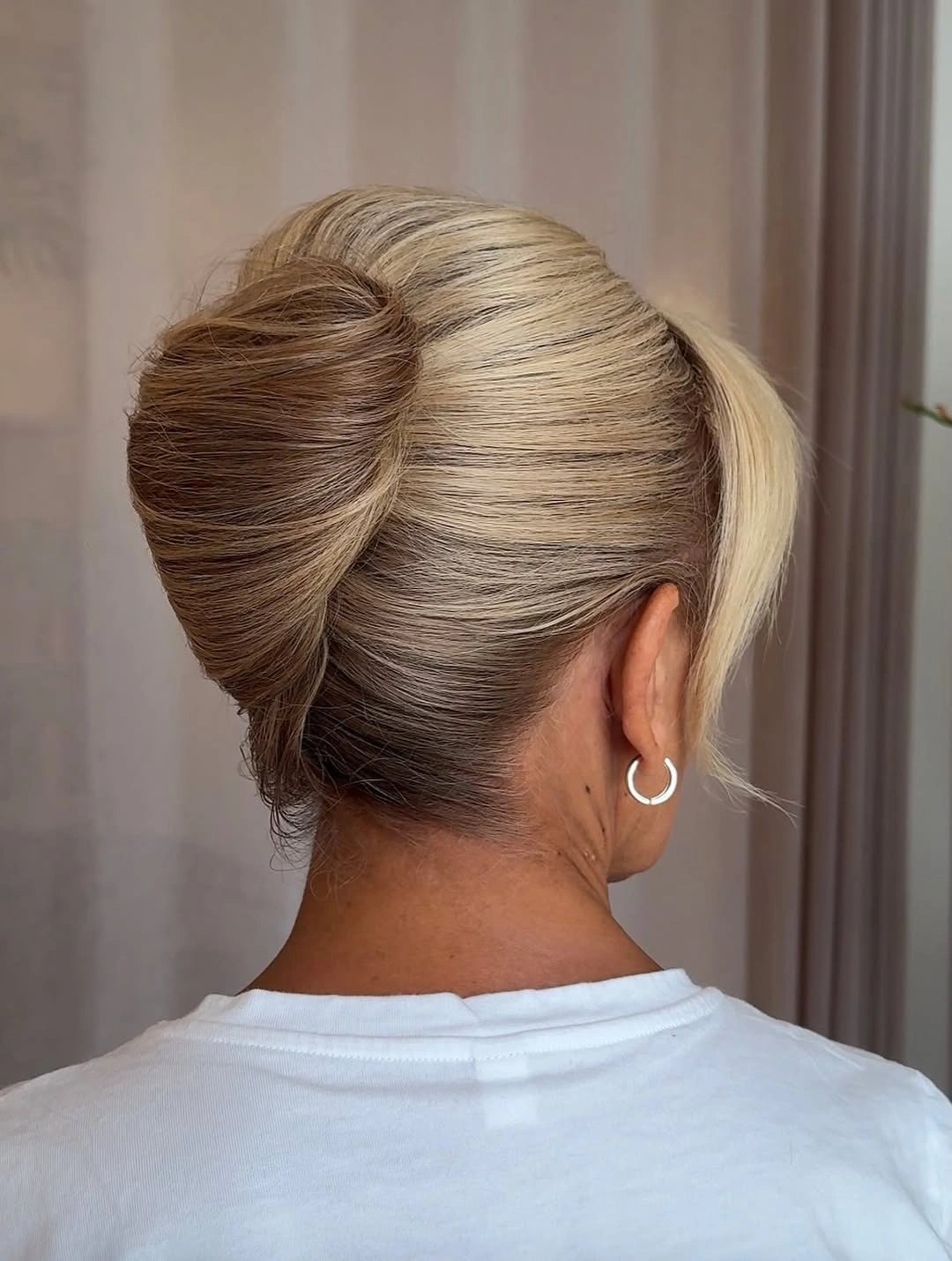 Fall hairstyles for wedding guests 2026 Polished Sculptural French Twist Bun for Classic Wedding Style