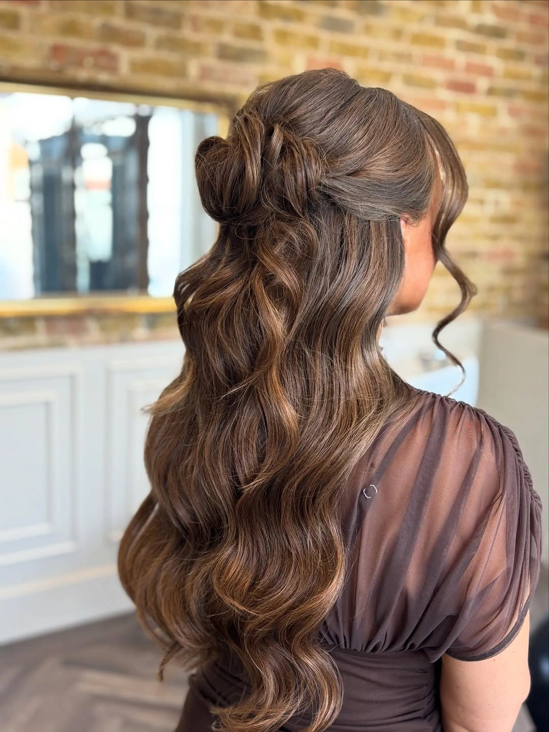 Fall hairstyles for wedding guests 2026 Soft Half-Up Knot with Flowing Chocolate Waves
