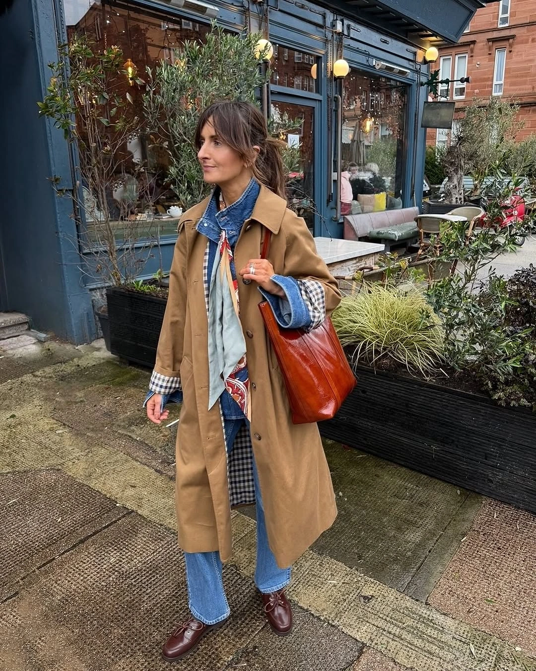 Trench coat fall outfits 2026 Denim Layers Make The Camel Trench Feel Relaxed