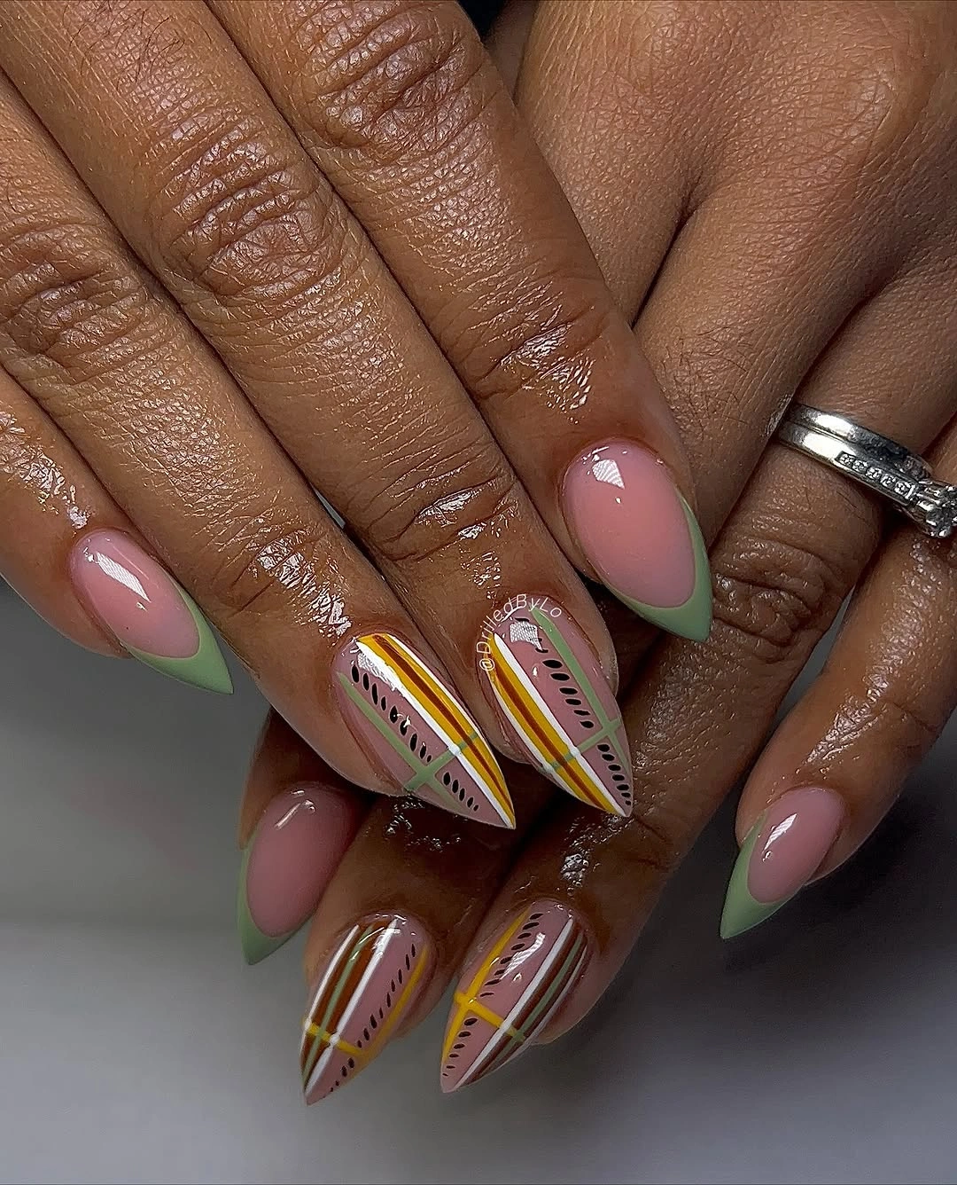 Long almond nails with brown green yellow and multicolor striped accents