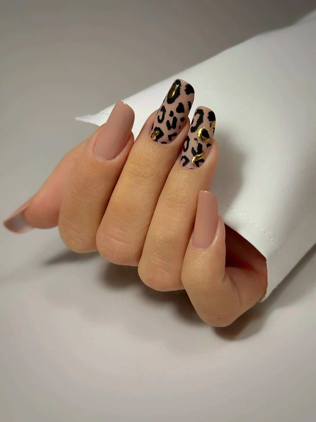 Medium nude nails with black and brown leopard-print French tips