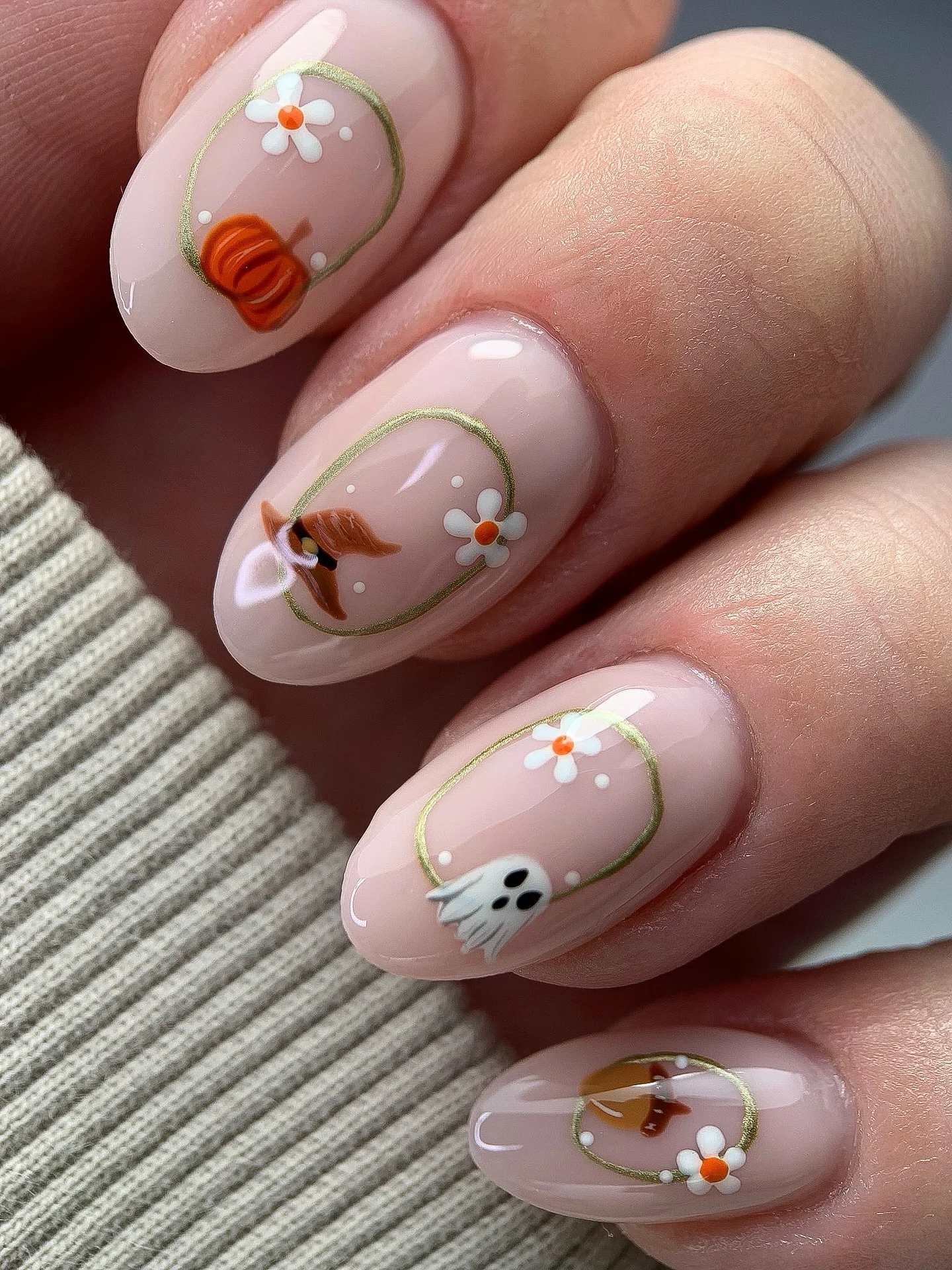 Short blush nails with tiny orange, green, and floral autumn motifs