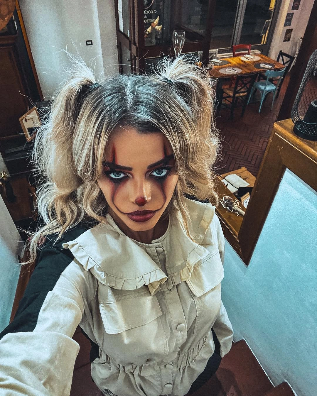 Creepy porcelain doll costume with ruffled blouse, pigtails, and dark makeup