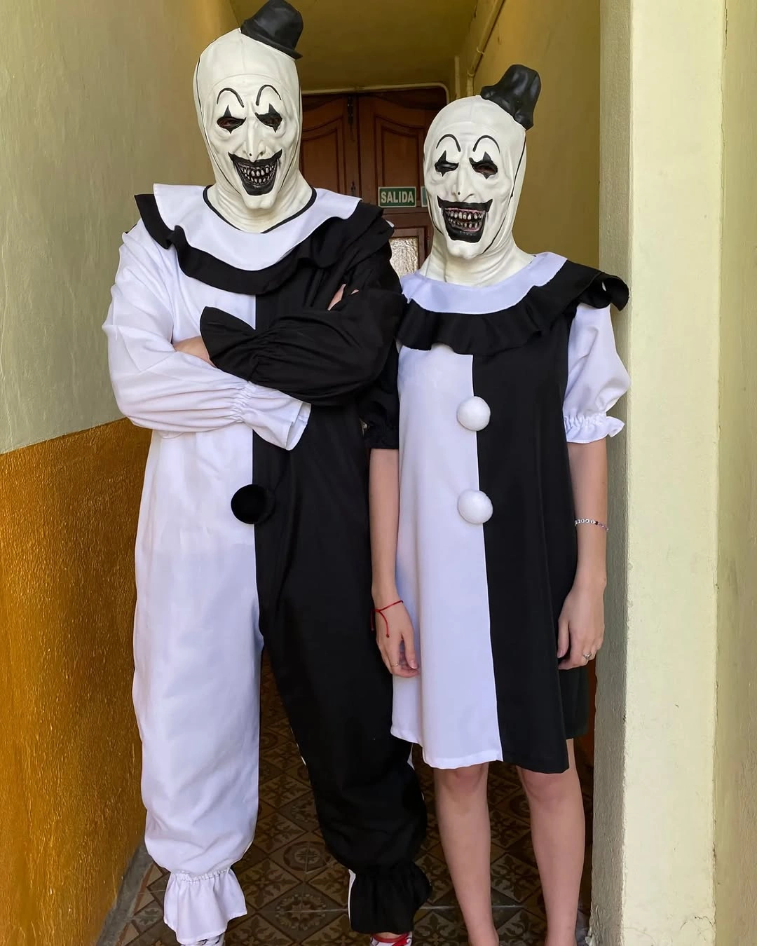 Two people dressed as Art the Clown from Terrifier in black and white