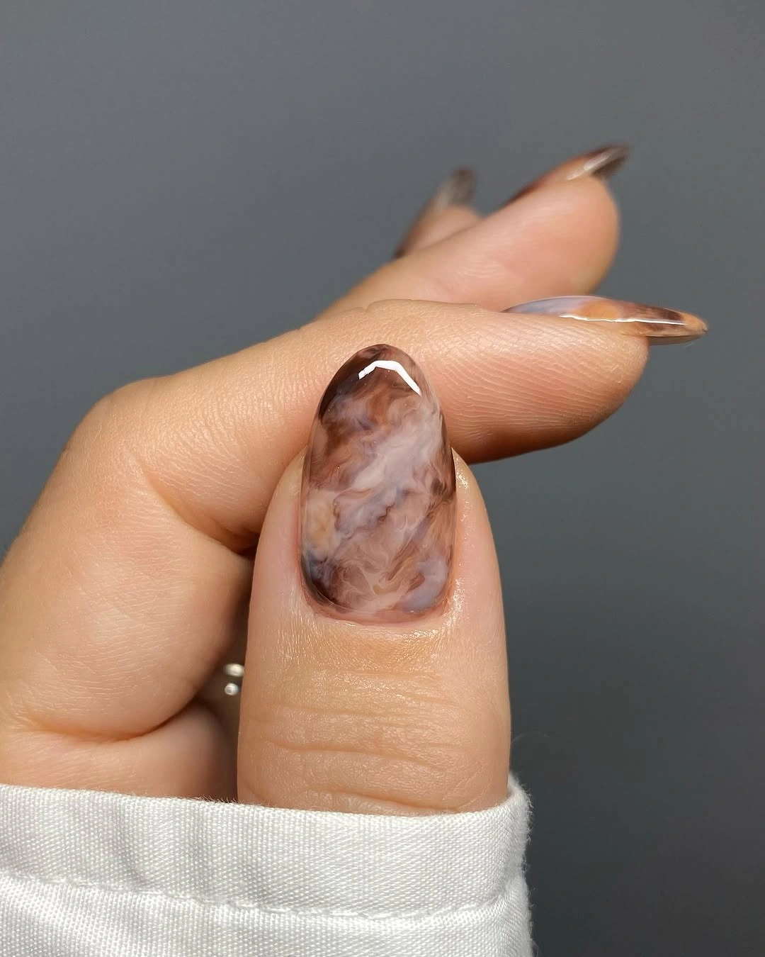 Long almond accent nail with cloudy brown and mauve marbling