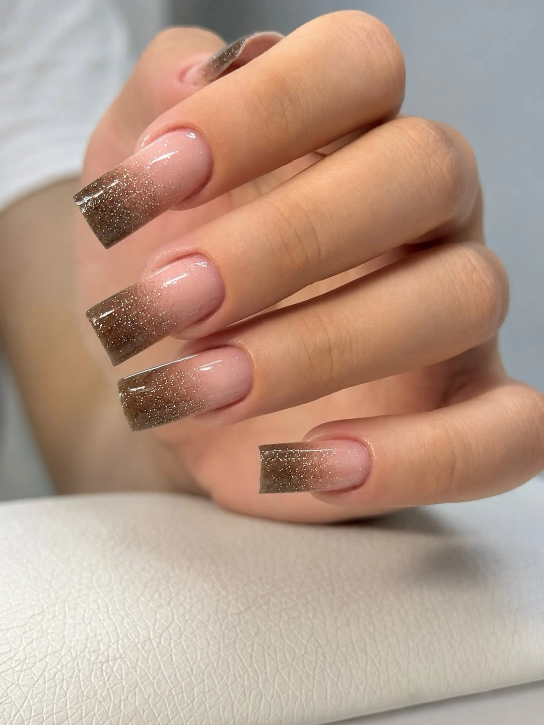 Medium square nails with sheer pink bases and brown French tips