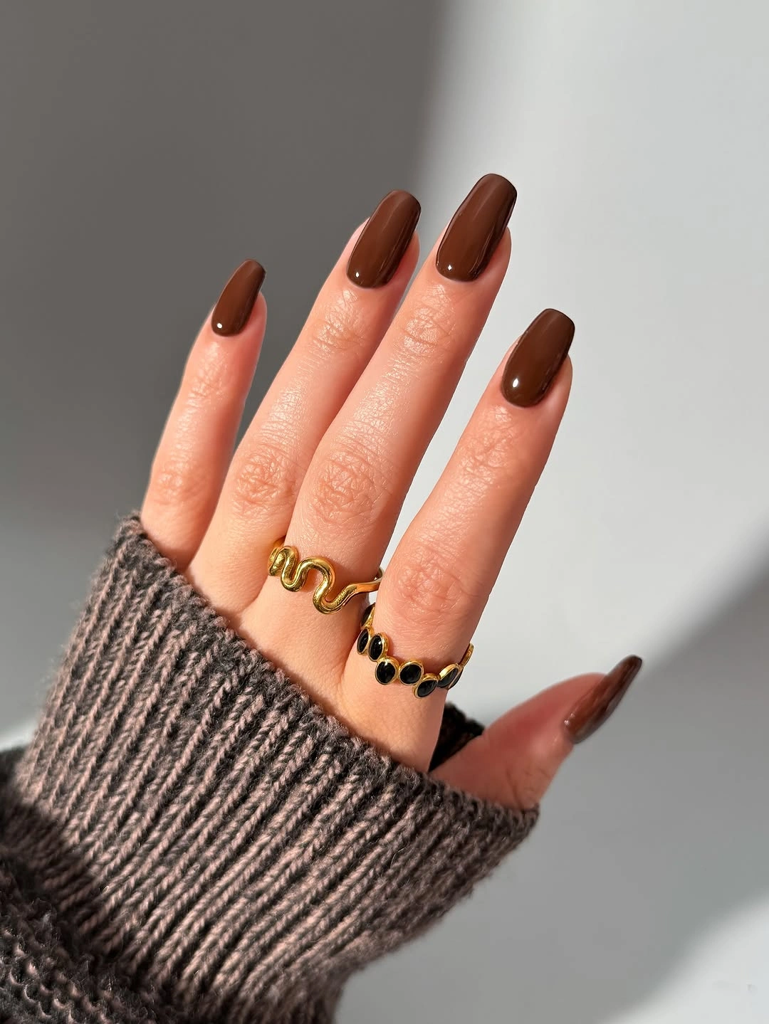 Medium almond nails in warm glossy chestnut brown