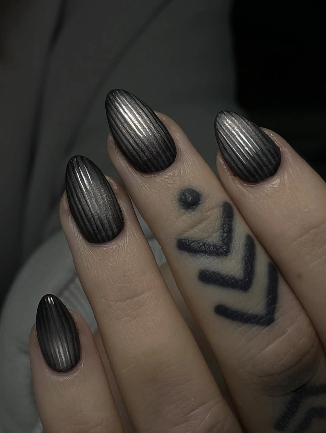 Charcoal almond nails with pronounced vertical ribbed texture