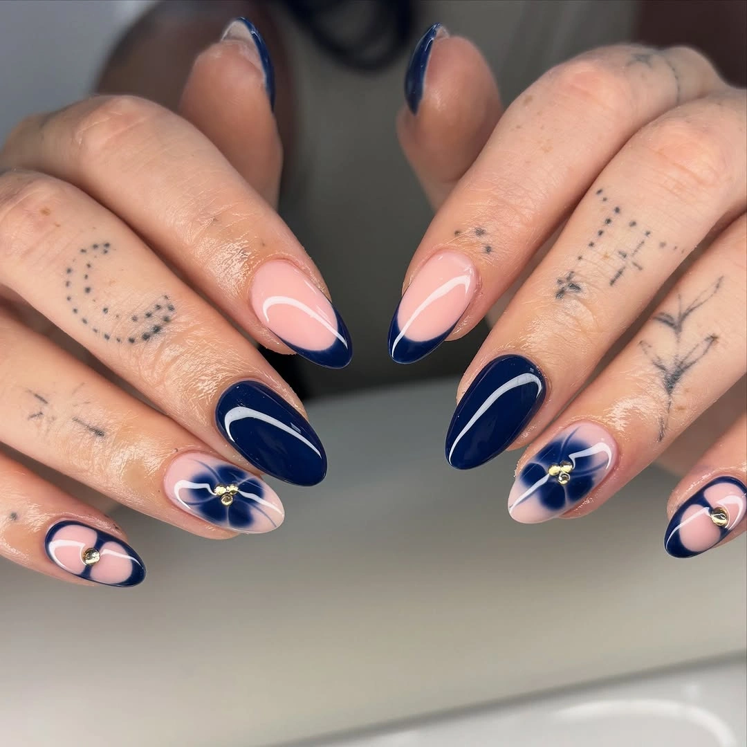 Long navy French almond nails with tiny gold floral accents