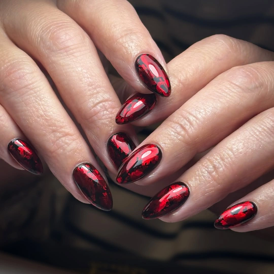 Dark wine almond nails with irregular red reflective patches