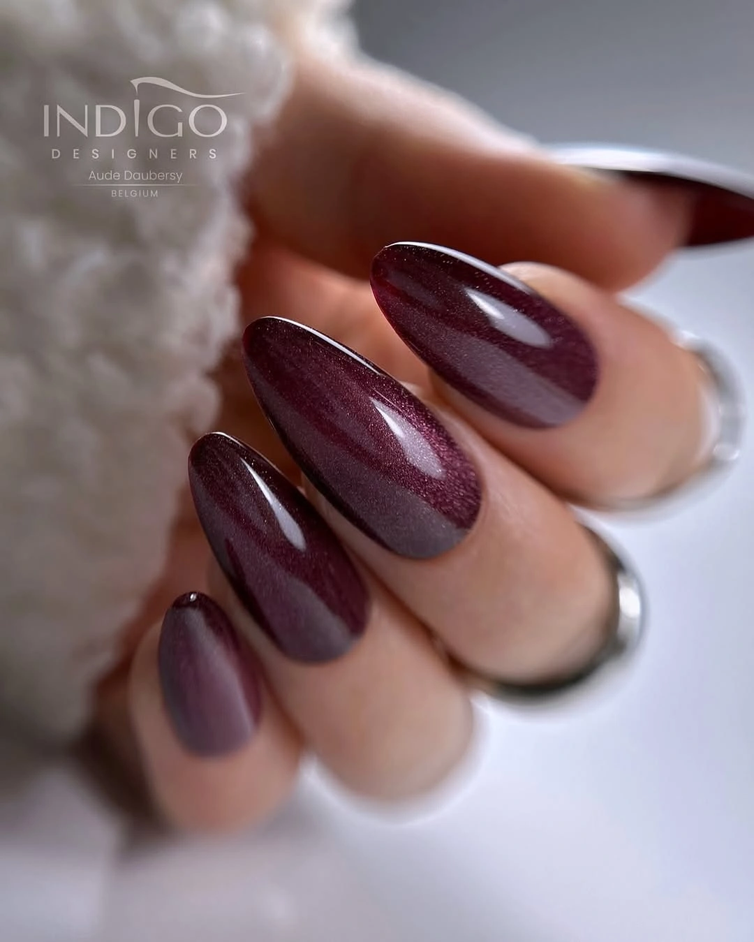 Deep berry almond nails with a subtle reflective center
