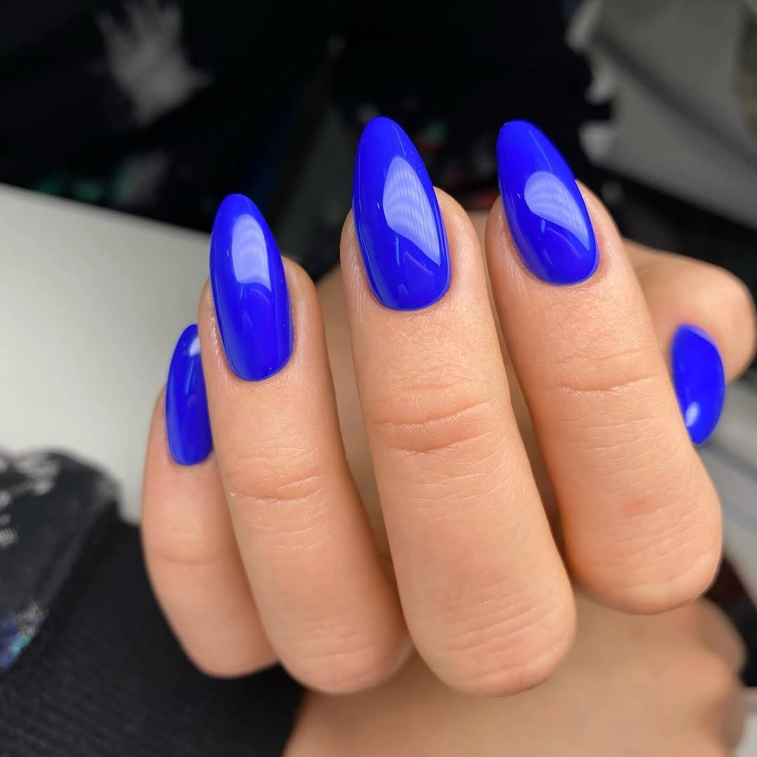 Long glossy cobalt blue almond nails in a single color