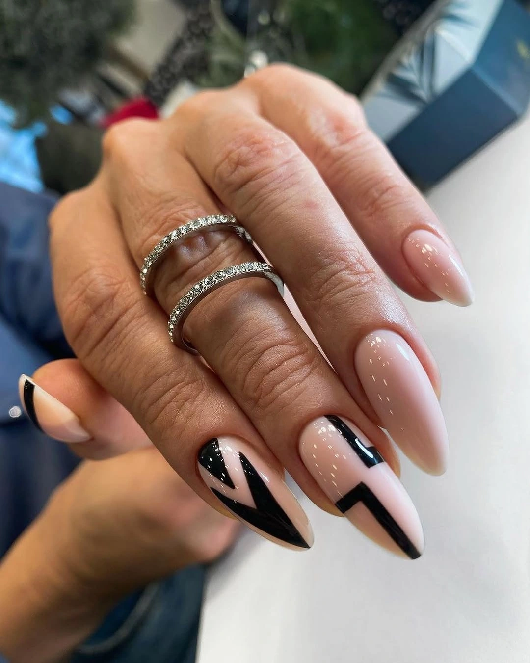 Nude almond nails with split black and white graphic tips