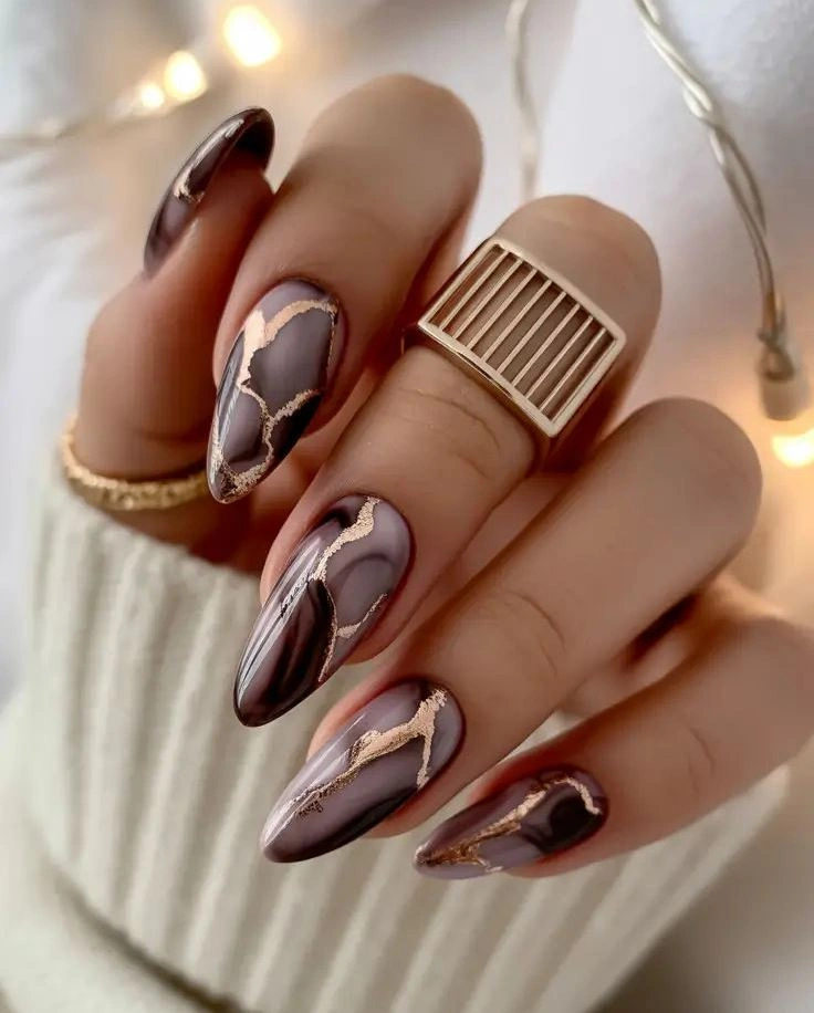 Plum almond nails with brown panels and thin gold outlines