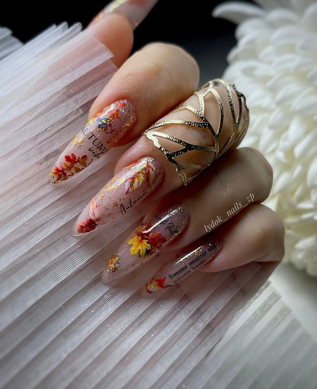 Long nude almond nails with orange flowers glitter and brown accents