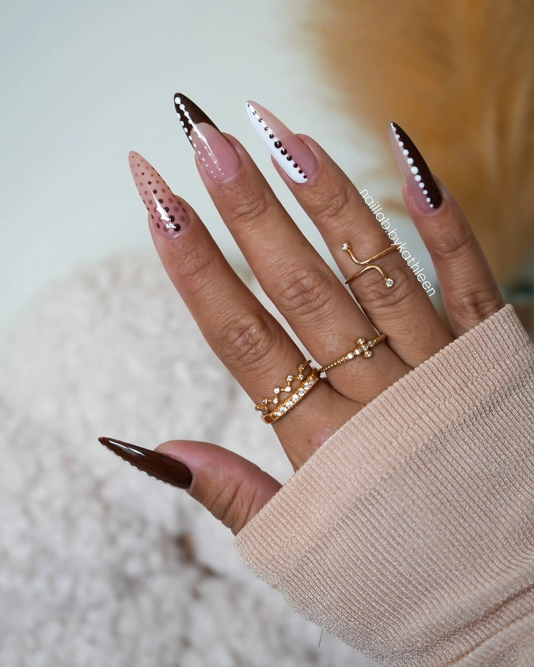 Nude almond nails with brown tips and black outlined accent edges