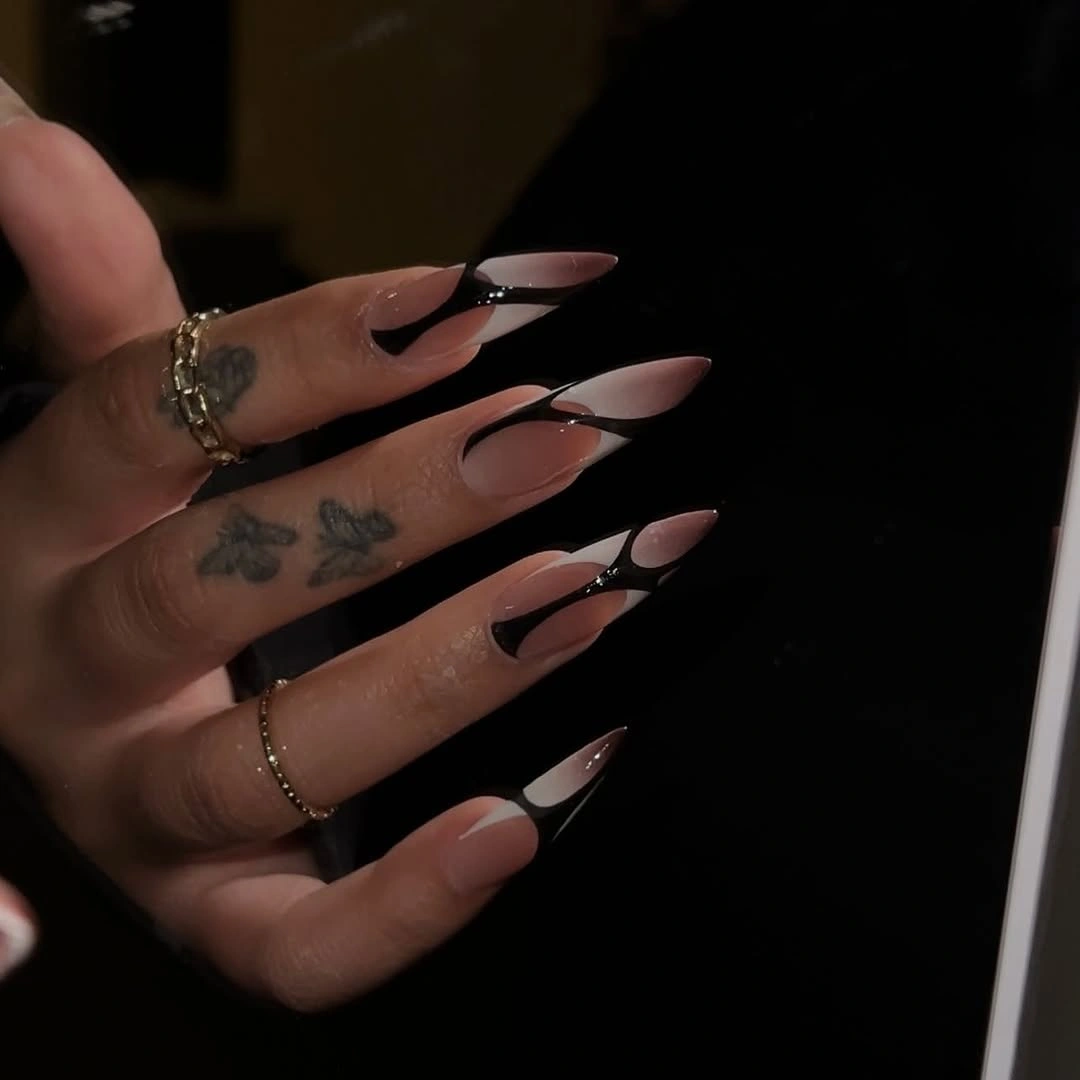 Long stiletto nails with nude base and black pink pointed tips