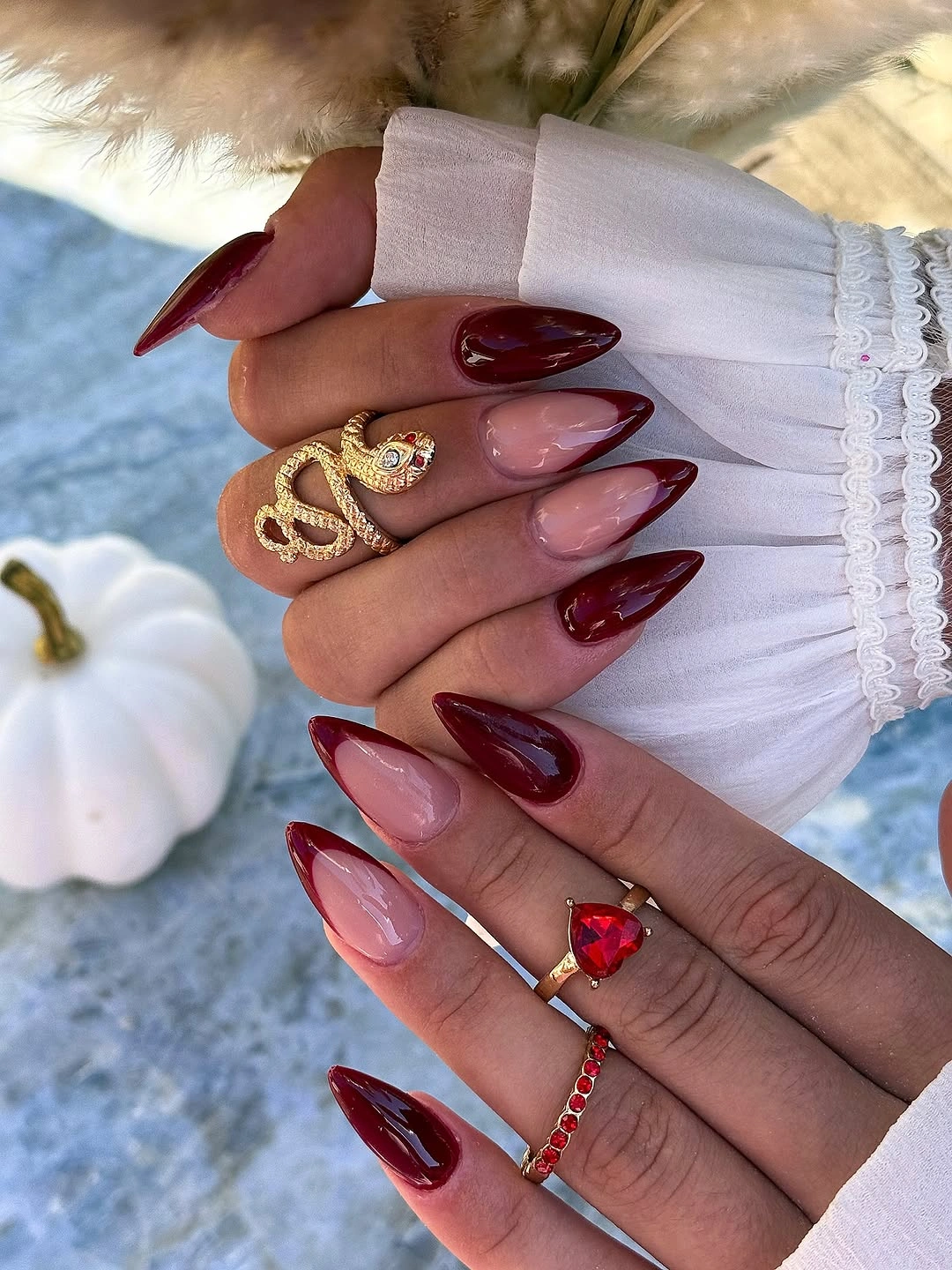 Glossy burgundy almond nails with gold fall accents