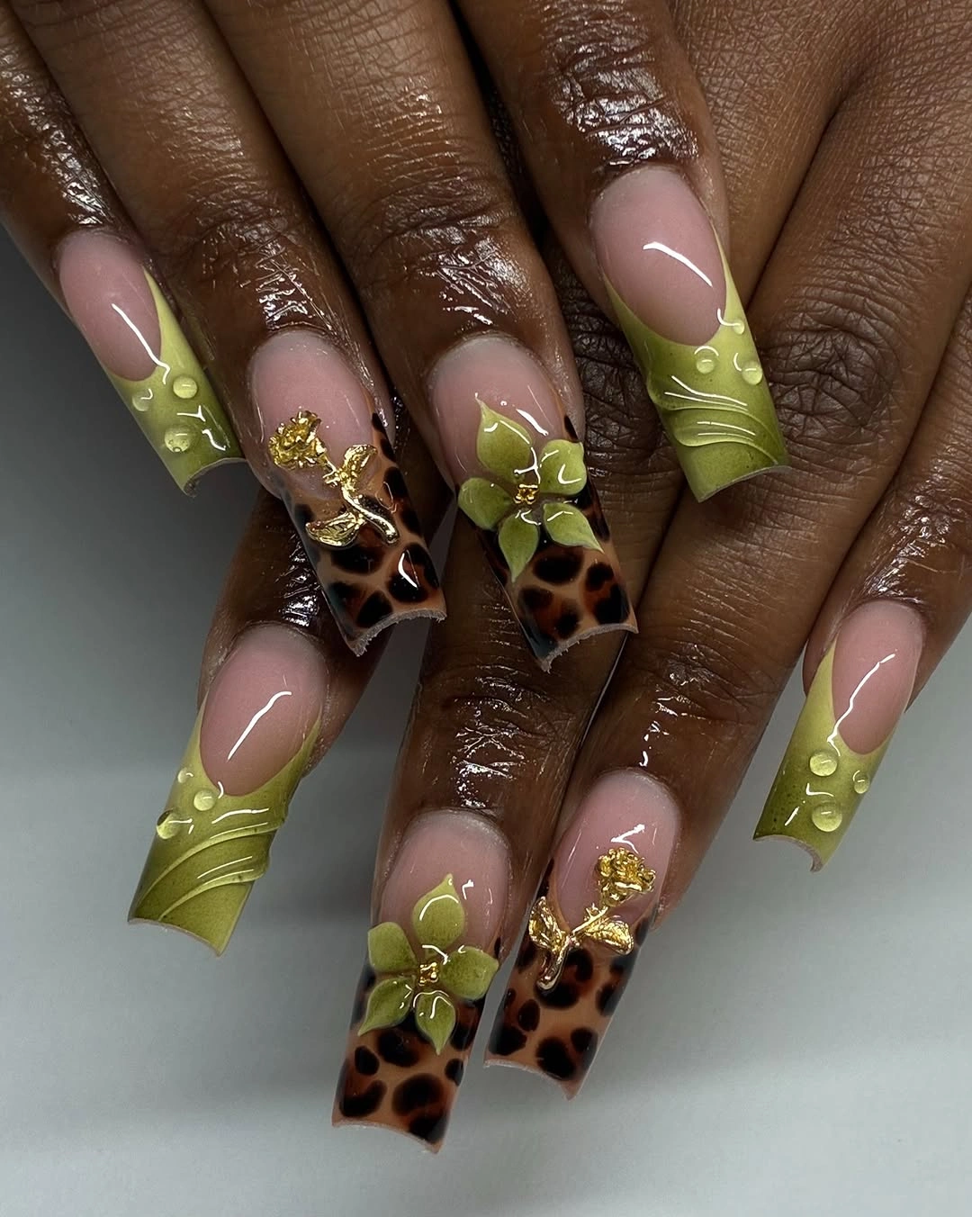 Olive almond nails with leopard gold and flower accents
