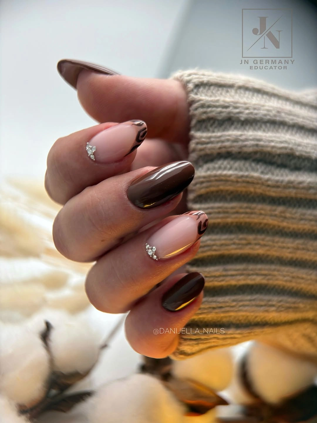 chocolate brown almond nails with blush swirls and crystals