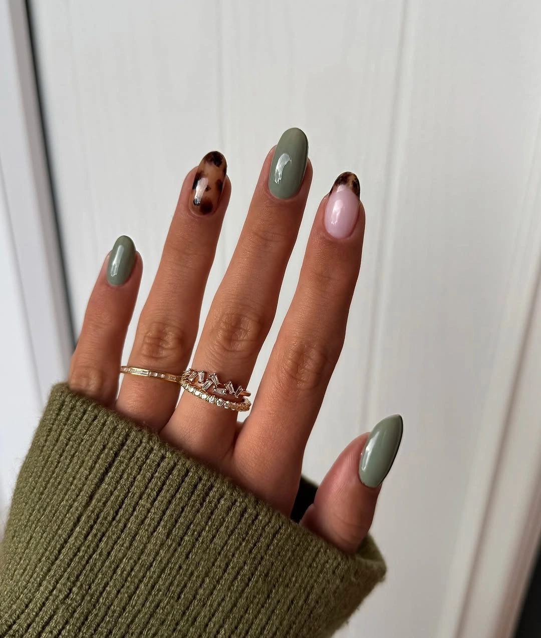 sage green almond nails with tortoise and pink accents