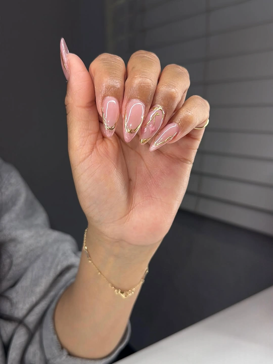 sheer pink almond nails with gold curved line art