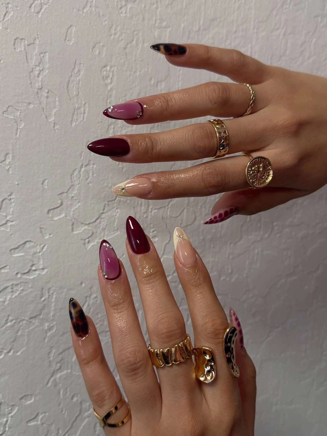 burgundy tortoise almond nails with blush gem accents