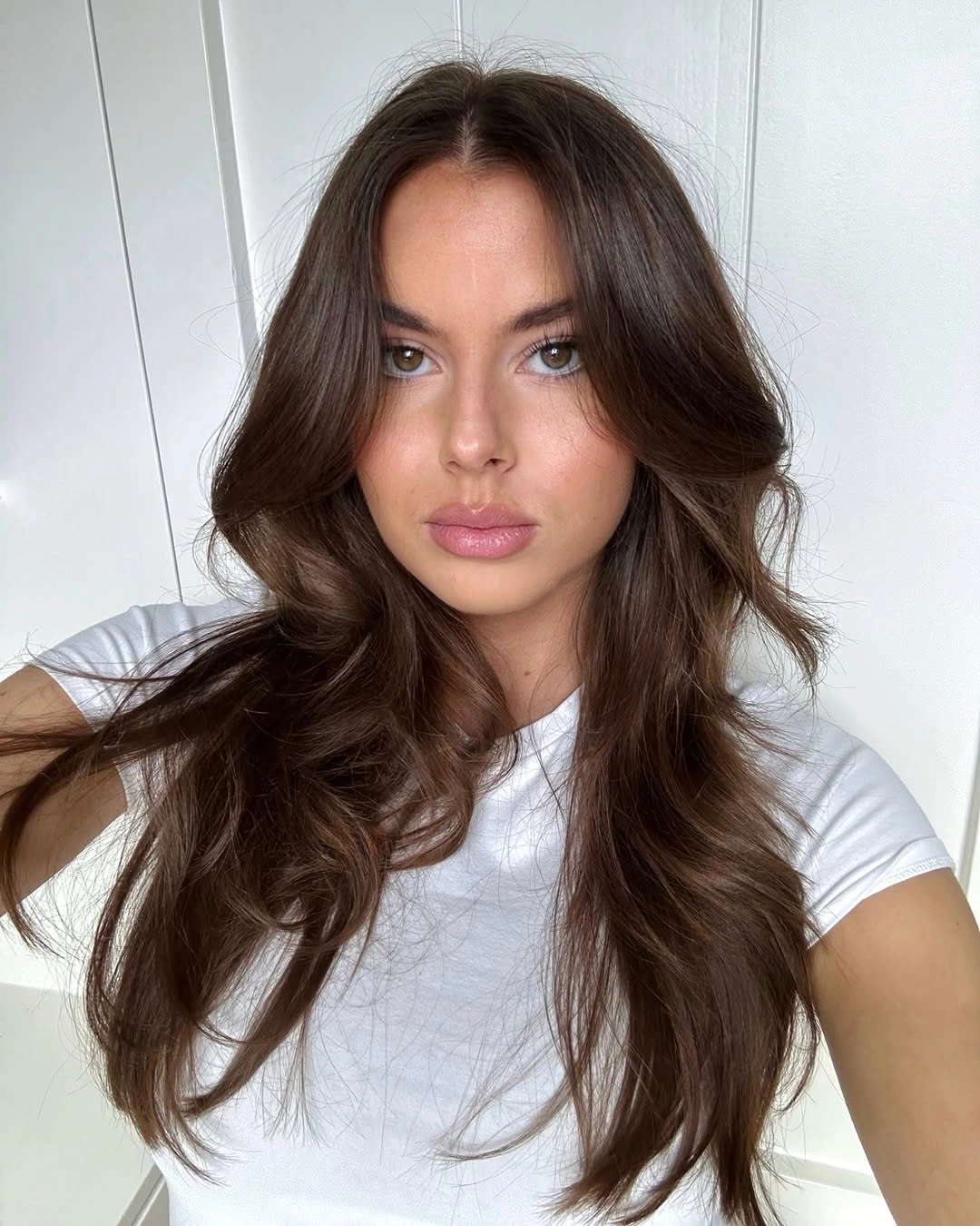 Deep brown face-framing layers with soft caramel movement