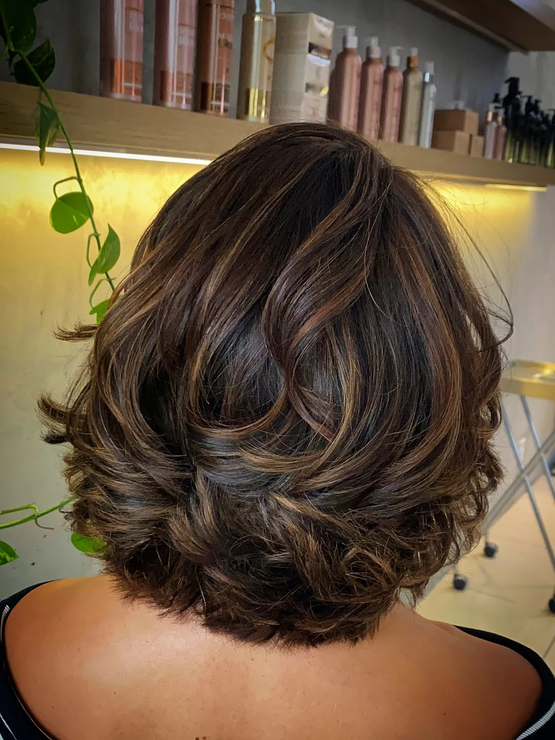 Short stacked brunette curls with warm brown dimension