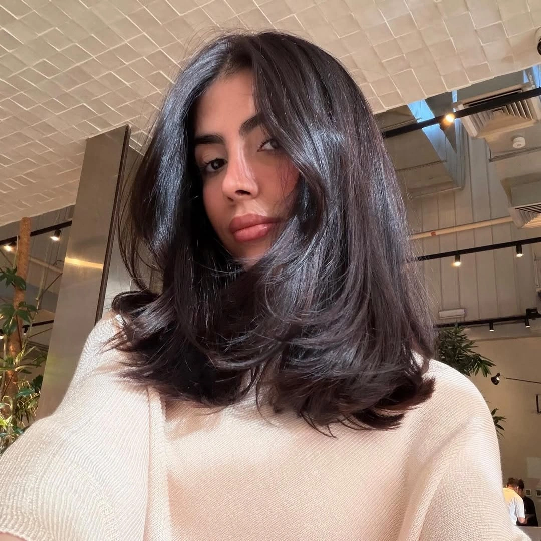 Shoulder-length deep brunette hair with full flipped layers