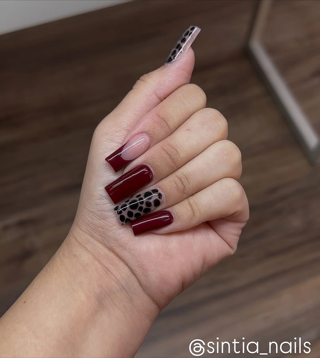 Long square burgundy nails with one spotted accent panel