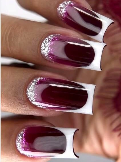 Long square burgundy nails with white framing and glittered bases