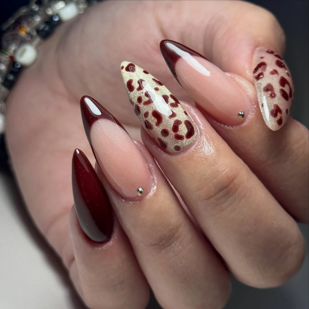 Long almond burgundy French nails with creamy leopard accents