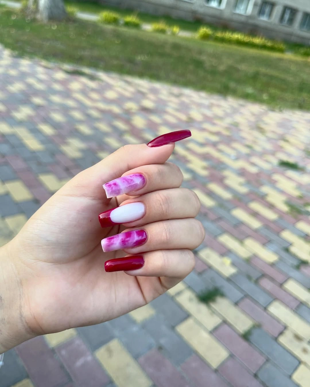 Long square burgundy nails with pale pink marbled accents
