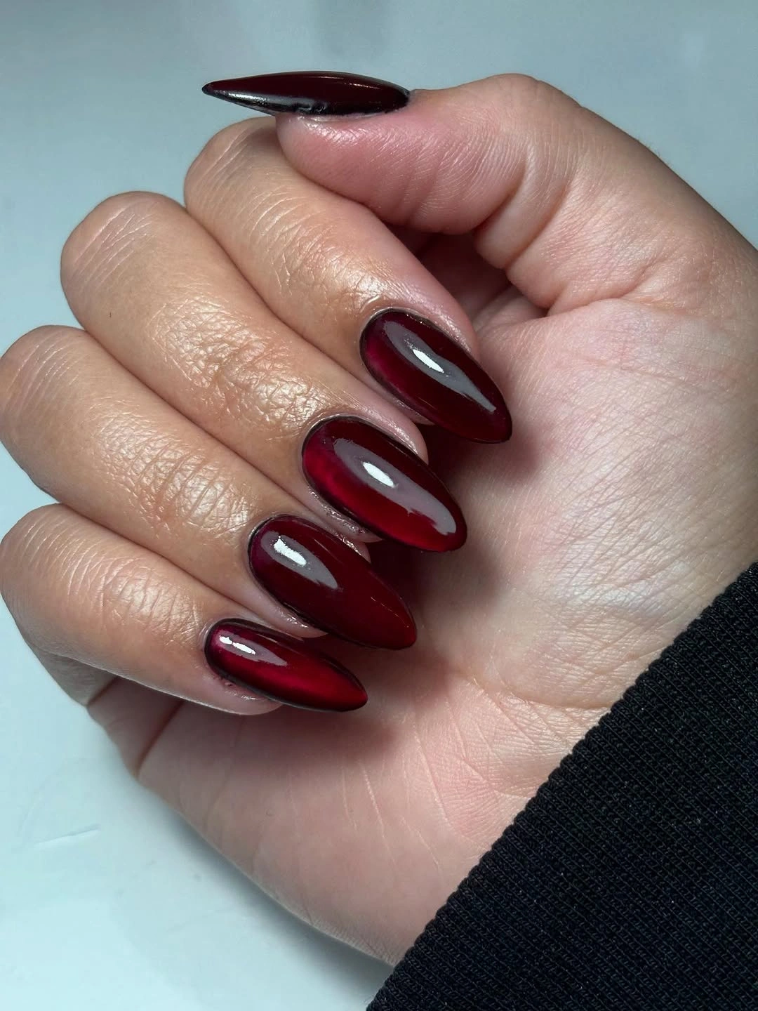 Long almond nails in deep glossy wine burgundy