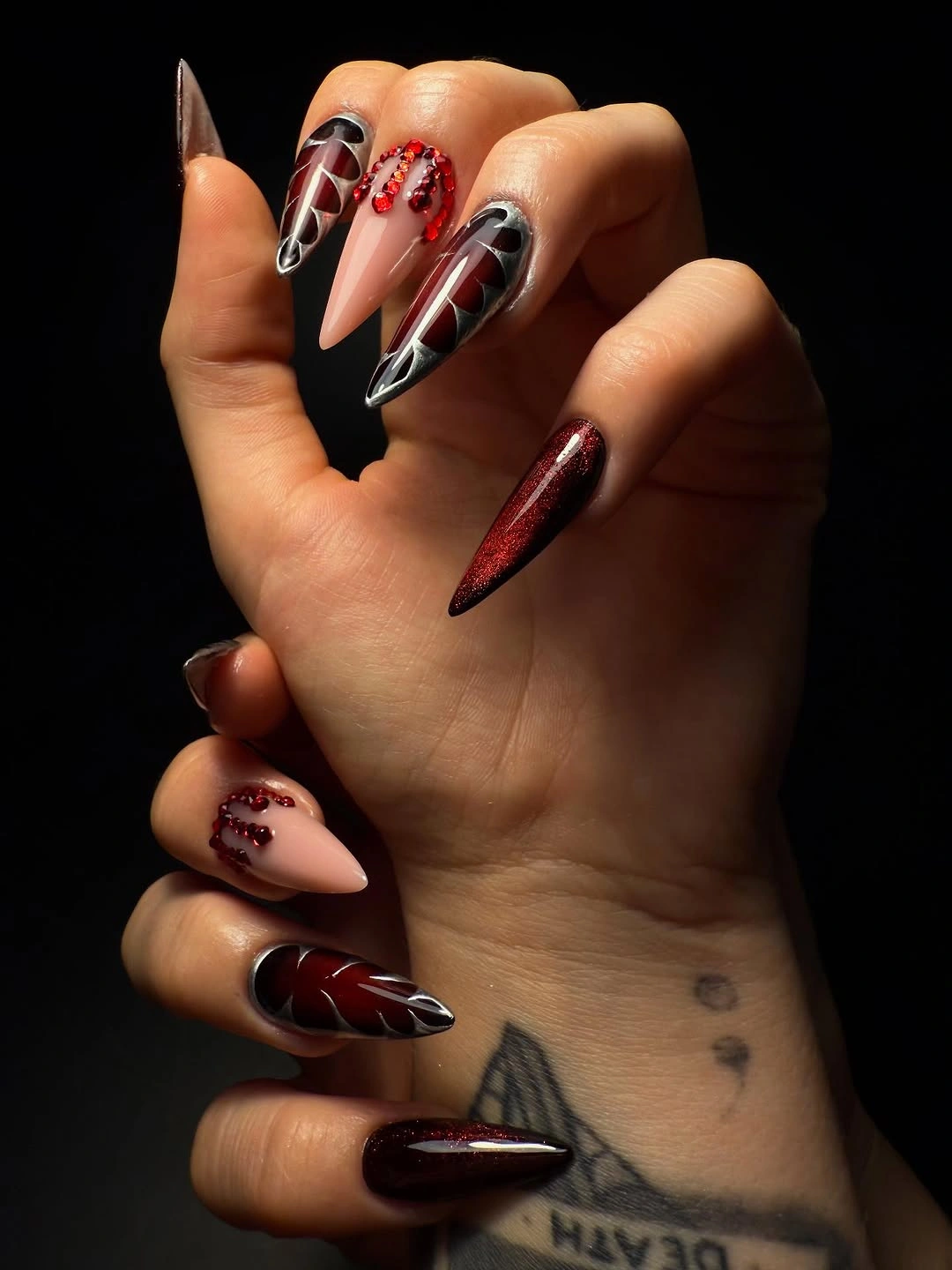 Very long stiletto nails with burgundy ribbon linework