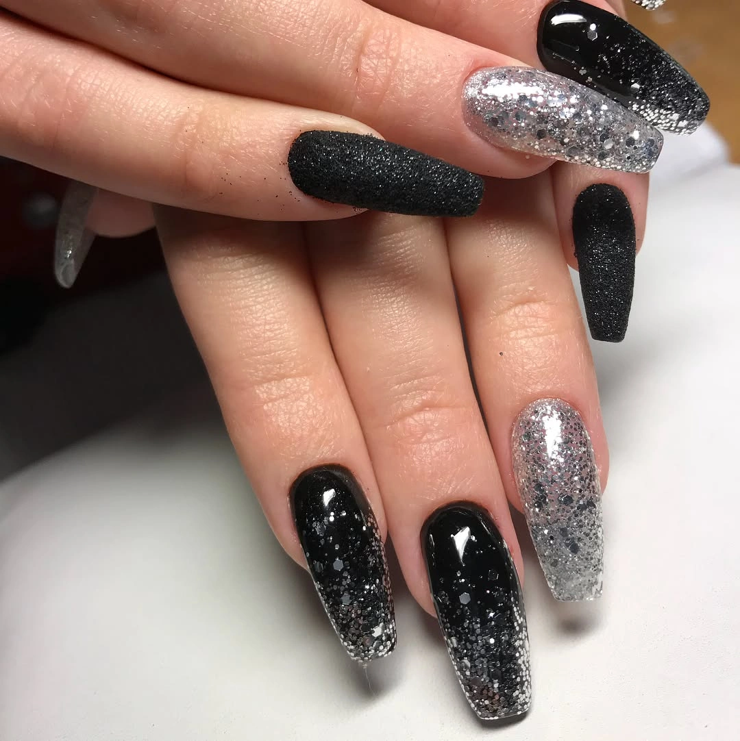 Long black textured nails with concentrated silver glitter accents