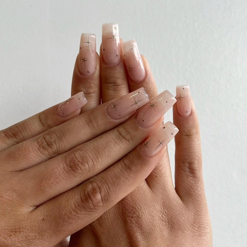 Long square nude nails with sparse dark tip marks fine lines and tiny dots
