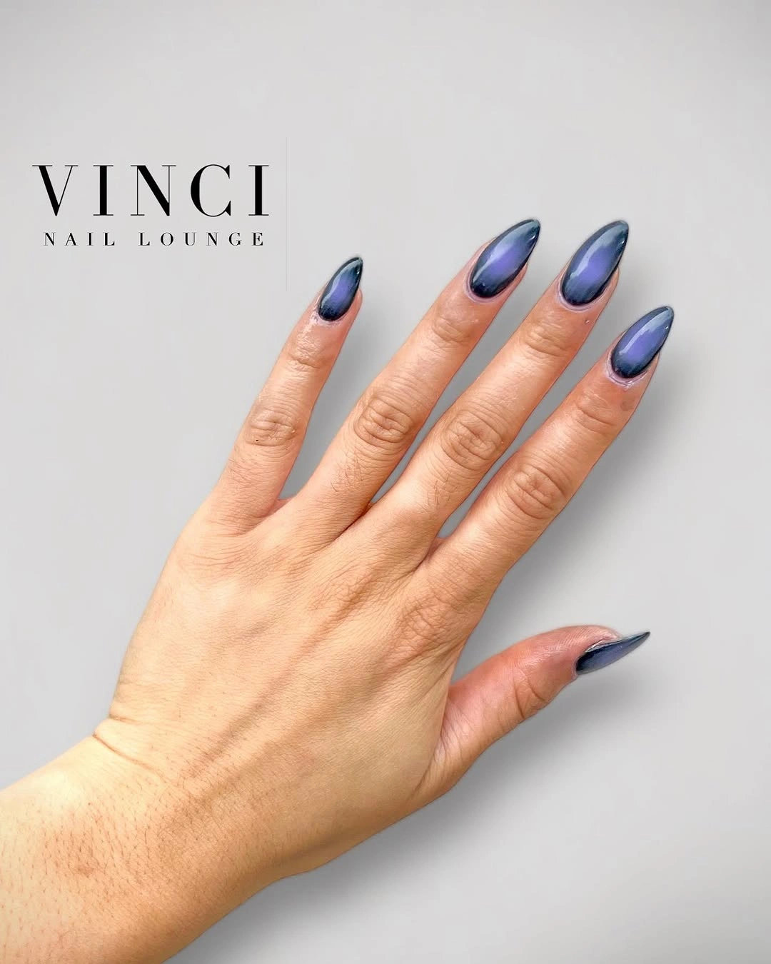Medium almond nails with blue-violet gradient reflective-looking shift and small pale dots