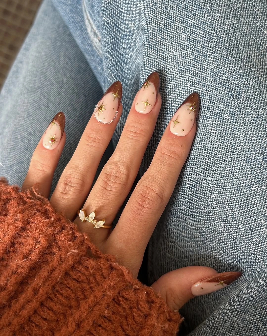 Milky almond nails with tiny brown amber and red accents