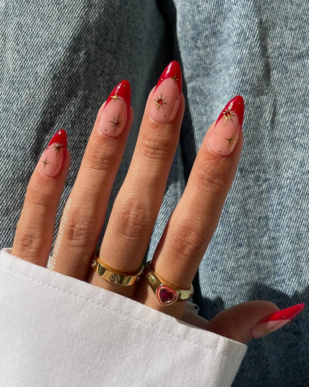 Long almond nails with bright red French tips and dark accents