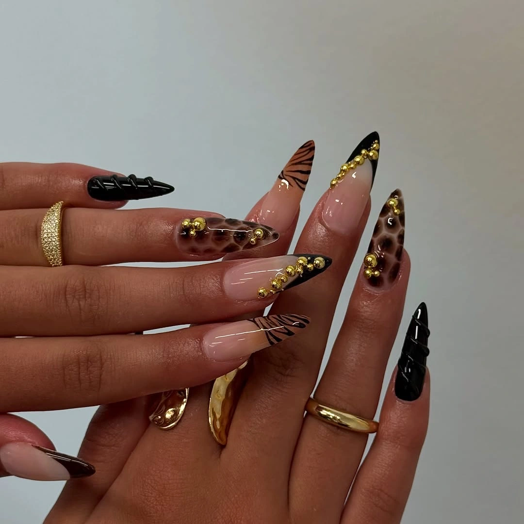 Very long stiletto nails with black tips gold and brown accents