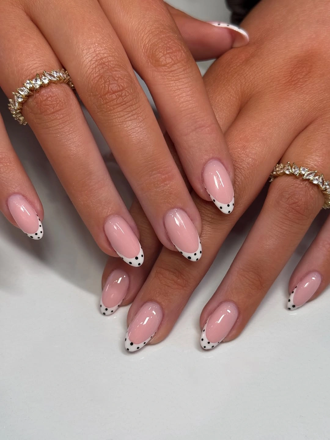 Blush almond nails with outlined black and white French tips