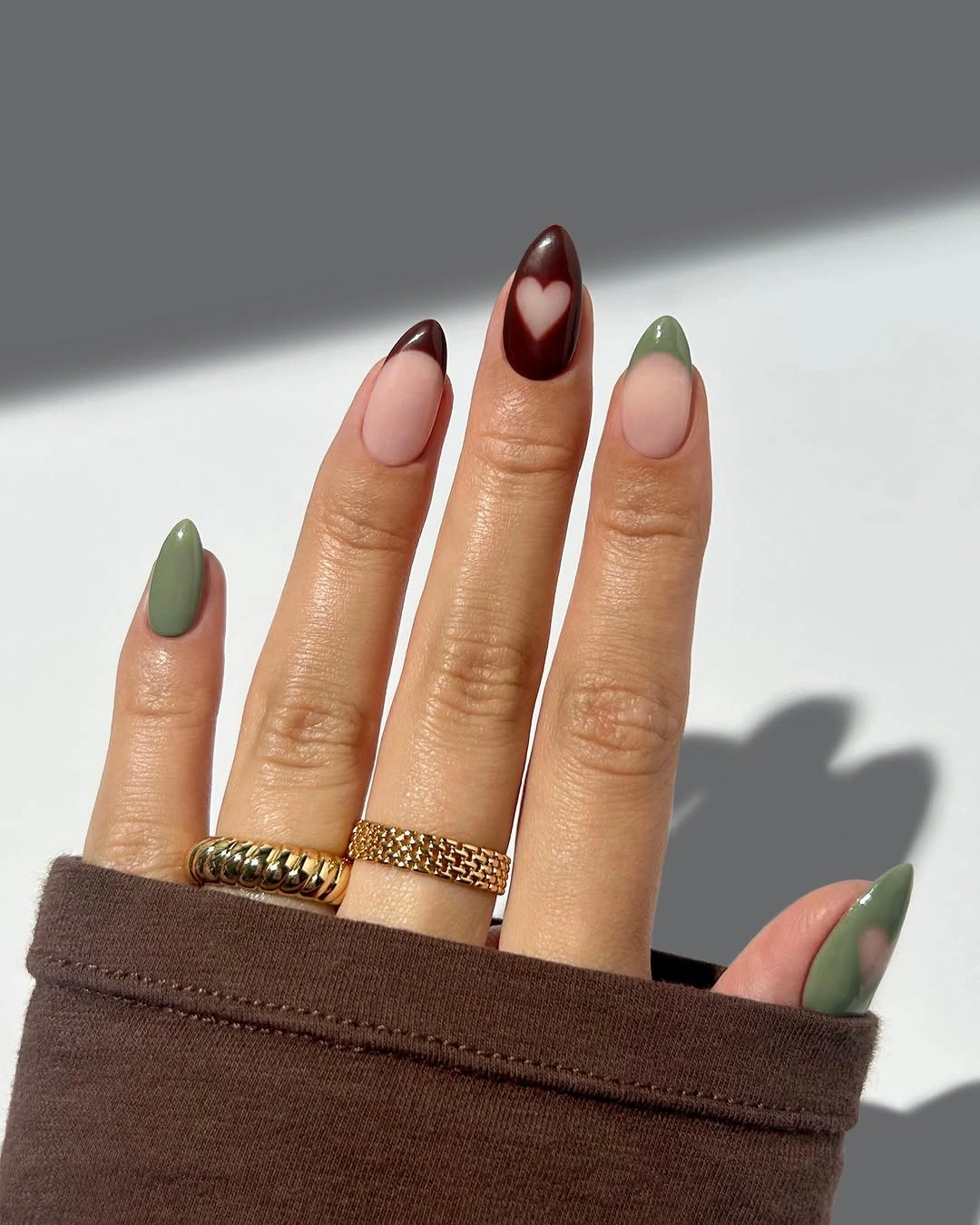 Medium almond nails with olive French tips and one graphic accent